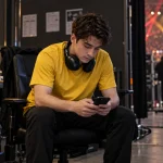 Backstage player checks phone before match